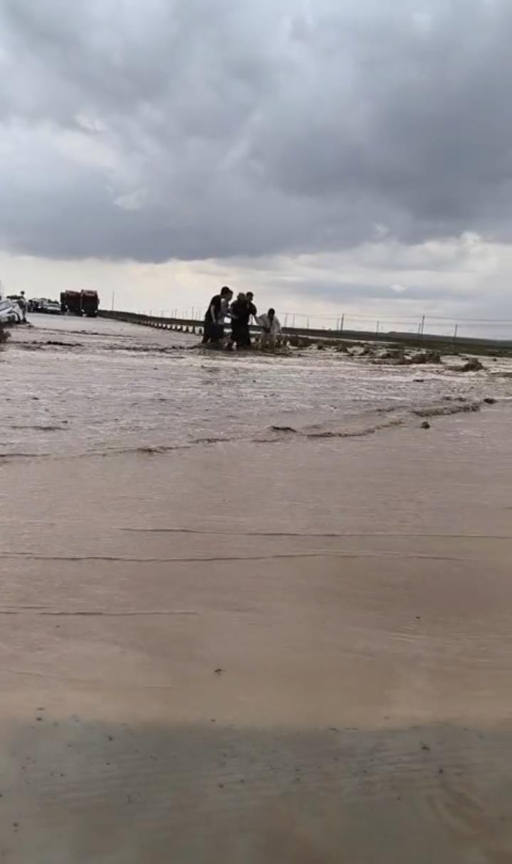 内蒙古一地洪水淹没公路两车被困，众人穿过急流接力救出一位老人