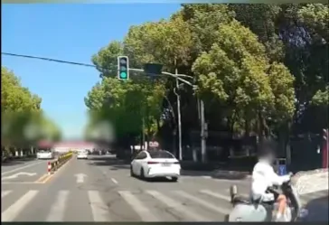 事发上海街头，女子骑电动车闯红灯，逼停一辆车后还继续往前骑，结果……