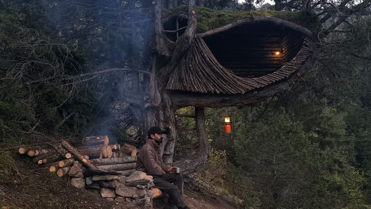 为了躲避森林中野兽的侵袭，男人把庇护所搭建在距离地面两米的