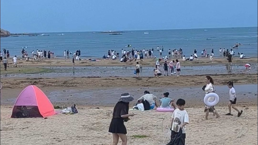近日，山东威海。偶遇沙滩最美风景！家长以身作则带娃捡拾垃圾，保