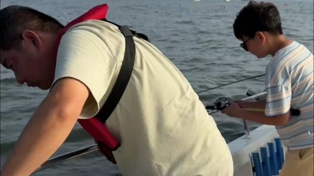 父子俩配合默契，一个打窝一个钓鱼