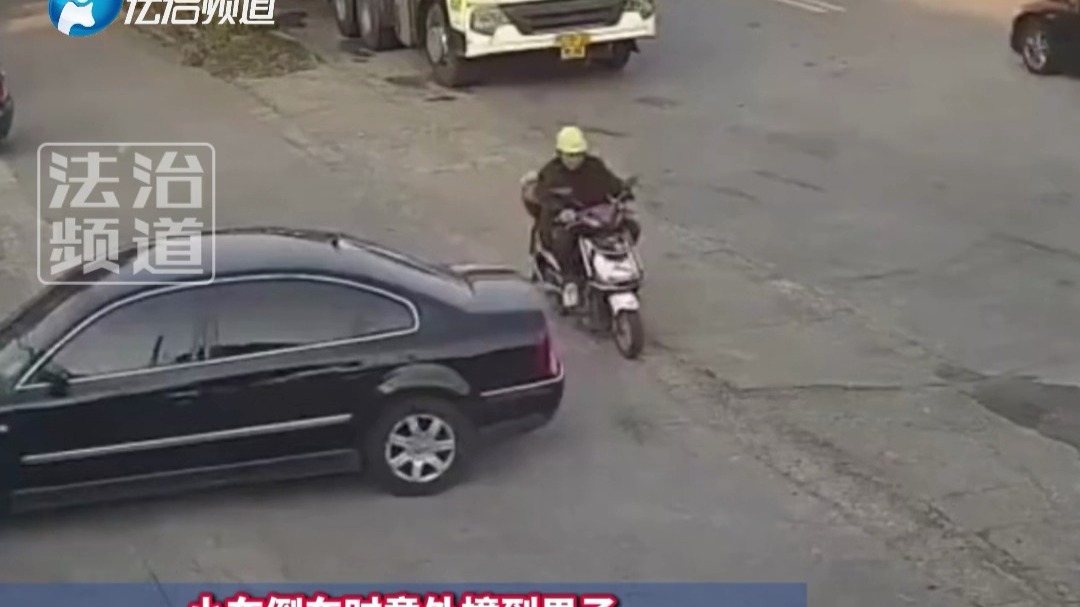小车倒车时意外撞到男子 男子顺势直接倒地