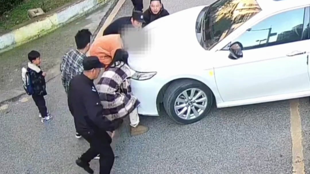 众人合力抬车，用57秒救出被卷入车底的男孩
