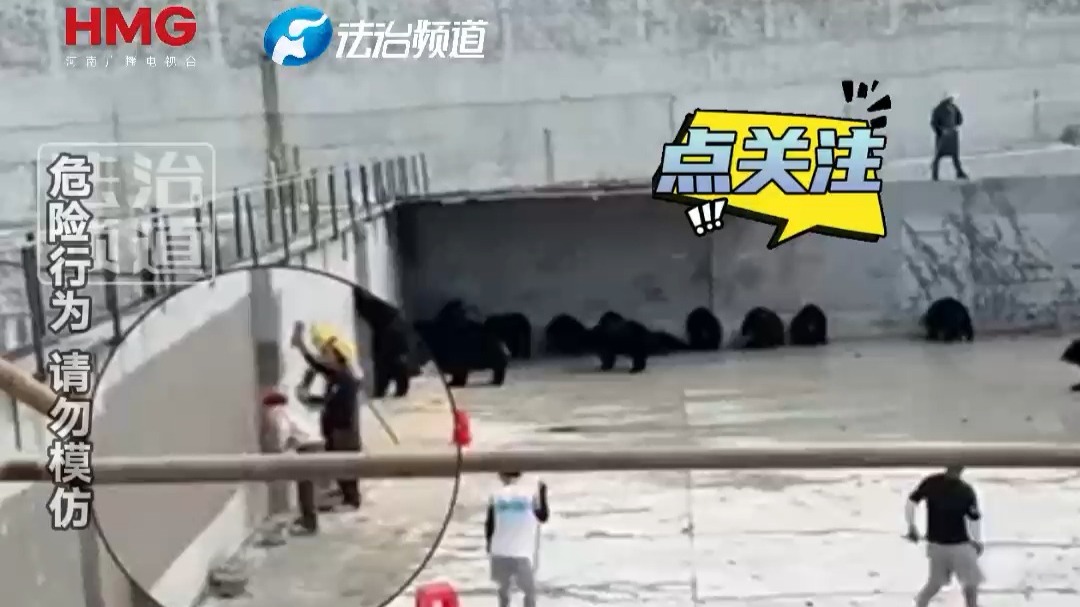 工人给熊山墙面涂漆 工作人员拿棍子在旁守护