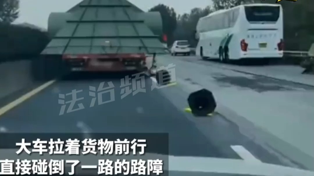 大车拉着货物前行 直接碰倒了一路的路障